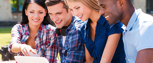 Group of young adults looking at a laptop